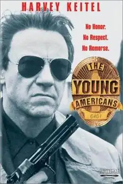 Portrait of Harvey Keitel holding a gun, with urban imagery behind him