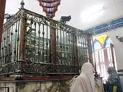 Photo of the shrine room in the mosque, containing the tomb of Imam Al-Busiri, as well as displaying muqaranas and arabic calligraphy