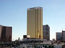 Ground-level view of a building with a rectangular cross section and a golden glass facade