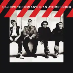 A monochrome image of all U2 members sitting near a wall