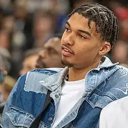 Wembanyama watching a NBA game from off the court.