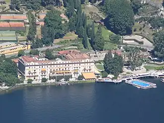View of a large lakeside villa complex with extensive gardens