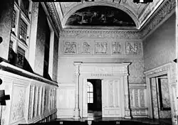 Music room in the residence at 451 Madison Avenue. There is a semicircular lunette panel atop the wall at the far end of the room.