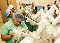 Image 39Medical personnel place sterilized covers on the arms of the daVinci Xi surgical system, a minimally-invasive robotic surgery system, at the William Beaumont Army Medical Center. (from History of medicine)
