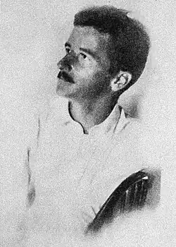 Photographic portrait of Faulkner seated in a chair.