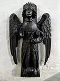 One of two wood carvings of angels in one of the side chapels in the church.